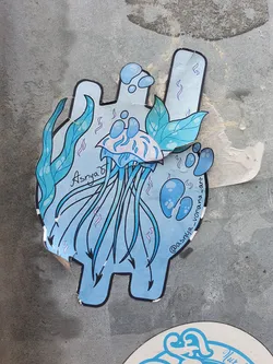 A light blue jellyfish sticker with seaweed and bubbles. The artist's Instagram handle is @asniya_vonana_art. The sticker is in the shape of a stylized figure.