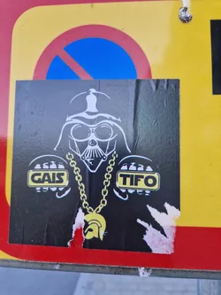 Street sticker A sticker depicting Darth Vader wearing a large gold chain and his hands are in the shape of the logos of the Swedish football clubs GAIS and TIFO.