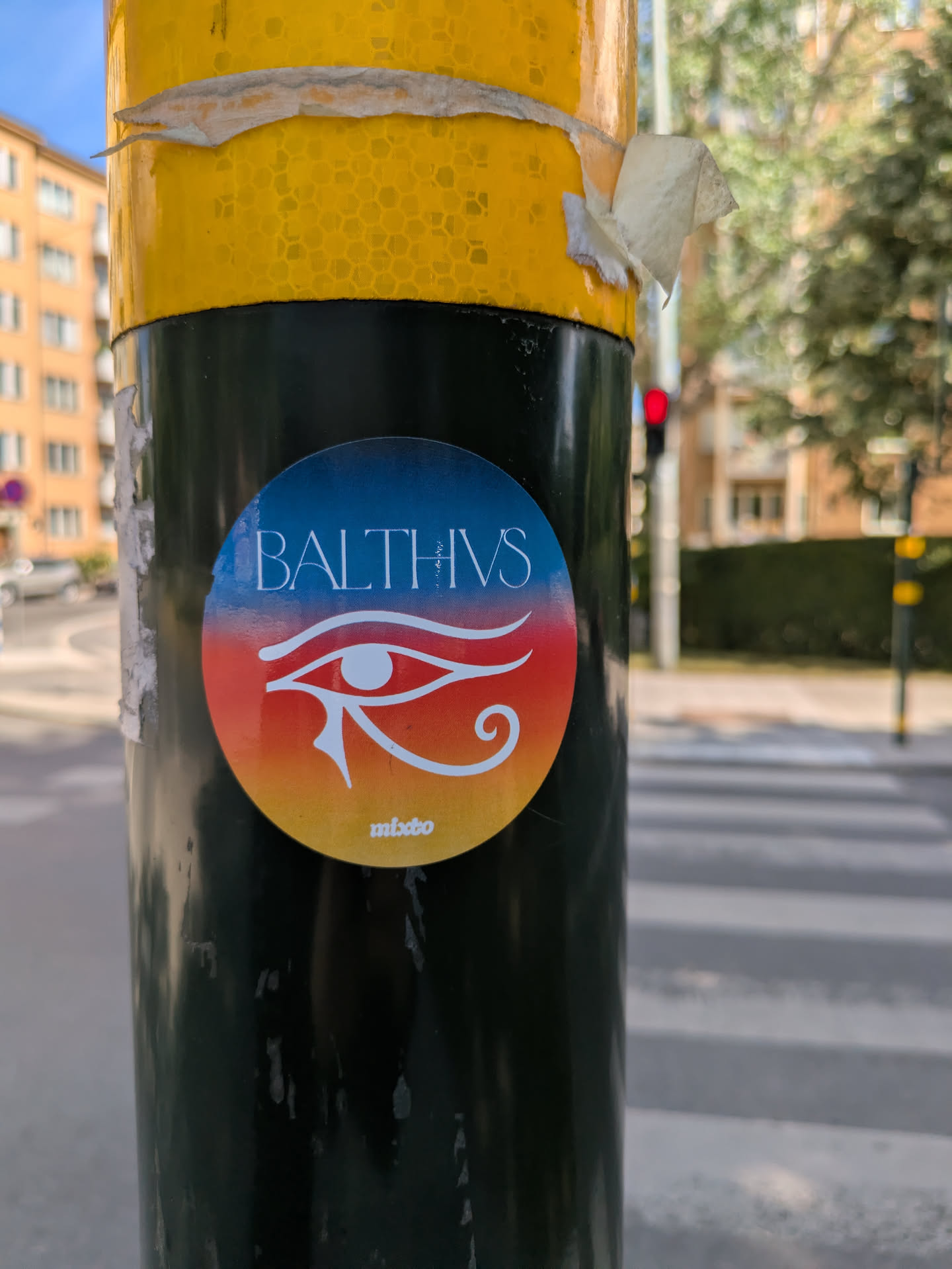 The sticker is circular and features a stylized Eye of Horus against a gradient background of blue, red, and yellow. The text "BALTHVS" is above the eye, and "mixbo" is below.