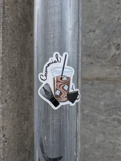 Street sticker A die-cut sticker depicting an iced brown latte in a plastic cup with a straw, a bamboo tea whisk, and a small steaming black cup. The word 'Ceremonial' is written in cursive script at the top.