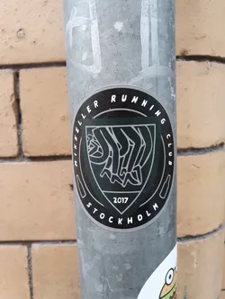 Black and white sticker with the Mikkeller Running Club Stockholm logo. The logo includes the text "Mikkeller Running Club" and "Stockholm" in a circle around a central emblem, which appears to represent runners. The year 2017 is visible at the bottom.