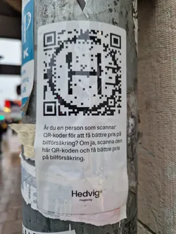 Street sticker A sticker with a QR code and text in Swedish. The text asks if you scan QR codes to get a better price on car insurance. If yes, scan this QR code to get a better price on car insurance. The sticker is from Hedvig, a car insurance company.