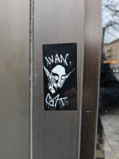 Street sticker Black and white sticker with a graphic design. It features a character with pointy ears, holding what seems to be syringes near the face. The text 'WANc.' is written above the character, and a tag 'GAT.' is visible below. 