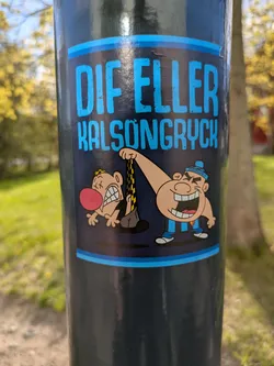 Street sticker The sticker, attached to a pole, features a cartoonish scene with the text "DIF ELLER KALSONGRYCK". It depicts one character pulling up the underwear of another character, causing the victim to grimace in discomfort. The style is reminiscent of classic cartoon humor.