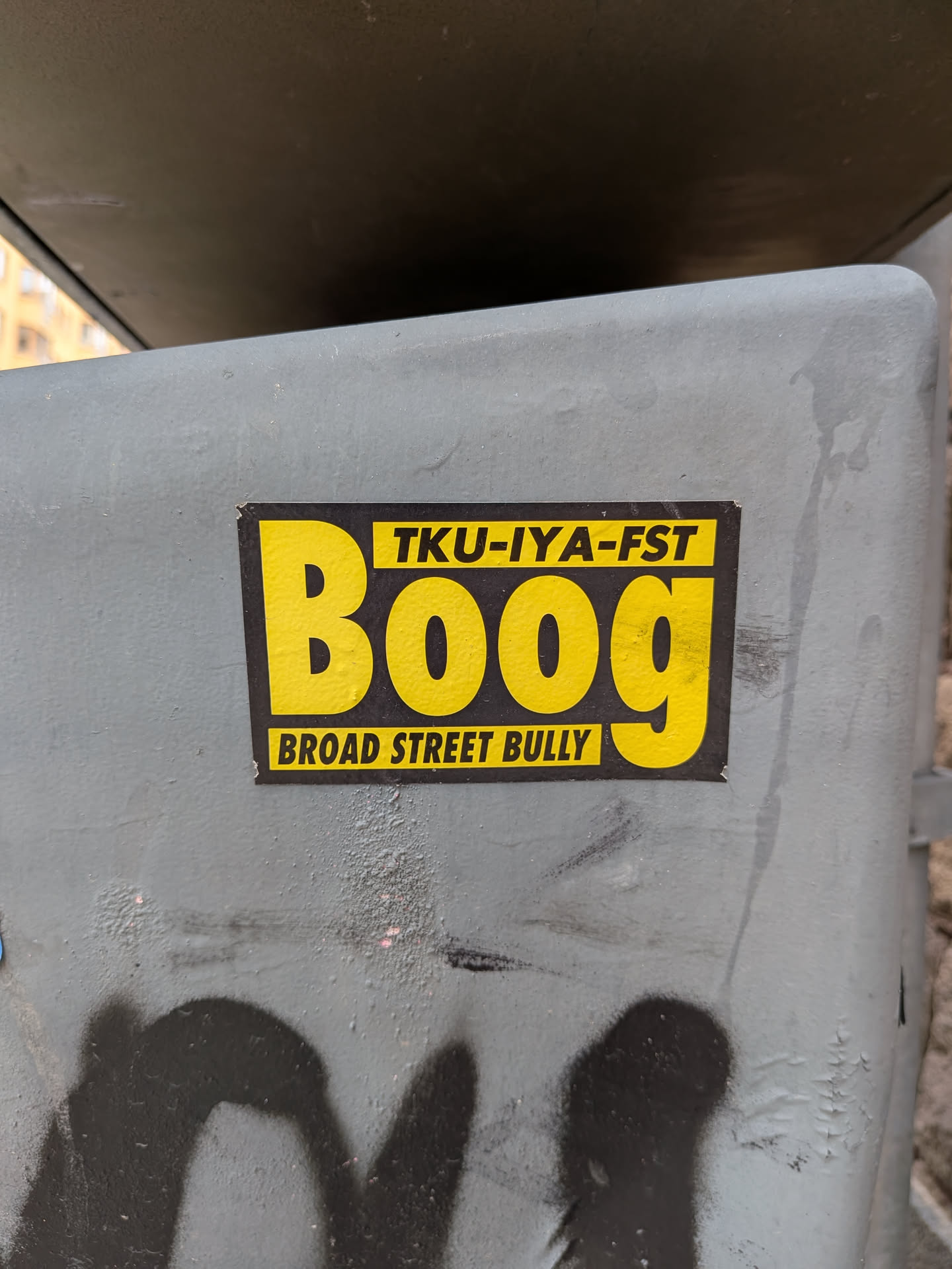 A rectangular sticker with a black background and bold yellow elements. The word 'Boog' is written in a large, stylized yellow font. Above the letters 'oog' is a yellow horizontal bar containing the black text 'TKU-IYA-FST'. Below the letters 'Boo' is another yellow horizontal bar containing the black text 'BROAD STREET BULLY'.