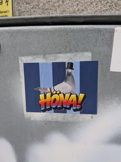 Street sticker A rectangular sticker depicting a realistic pigeon wearing a small black top hat. The background consists of vertical stripes in alternating shades of blue. In the foreground, the Swedish word 'HÖNA!' is written in a bold, 3D graffiti-style font with a yellow, orange, and red gradient, outlined in black and blue.