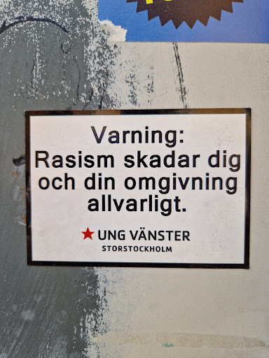 Street sticker A sticker warning against racism.  It's in Swedish and states that racism seriously harms you and those around you.  The sticker is from Ung Vänster Storstockholm (Young Left Stockholm).