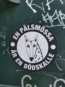 Street sticker A round black and white sticker with a stylized fox and text in Swedish.  The text translates to "A fur hat is a skull."