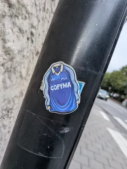 Street sticker A die-cut sticker depicting a classic blue long-sleeved football jersey with a white collar. The jersey features three white stripes down the sleeves, an Adidas trefoil logo on the right chest, 'FCL' on the left chest, and the sponsor name 'COPYMA' printed in large white letters across the center. The illustration has a textured, hand-drawn appearance.