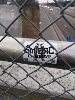 Street sticker A rectangular white sticker featuring a bold, black-on-white graphic. The central design consists of two highly stylized, mirrored bird-like figures, possibly woodpeckers or similar crested birds, facing each other. Their bodies are filled with intricate, almost tribal or punk-inspired patterns. Above the birds, the text 'SMEŘC' is written in a blocky, distressed font, and below them, the word 'BEAT' appears in a similar style. Two small, square QR codes are positioned in the bottom left and right corners of the sticker. The overall aesthetic is edgy and graphic.