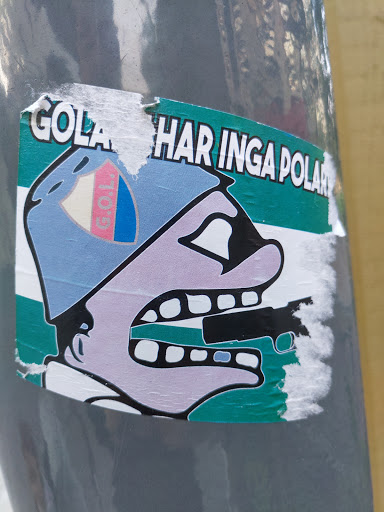 Street sticker A sticker featuring a cartoon character with a gun in its mouth. The text on the sticker says "Gola har inga polar!" which translates to "Gola has no poles!" in Swedish. The sticker is attached to a gray pole.