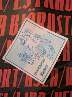 The sticker is square with a light blue border and image on a white background. The image shows a griffin stepping on a head. Below the image is the text 'Stockholms Blodbad'.