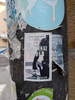 Street sticker A rectangular sticker displaying a book cover design. It features a dark silhouette of a police officer, a highway, and a police badge with a red Zia symbol. Text includes the title, author name, and a QR code.