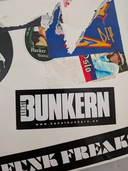A rectangular black sticker featuring prominent white typography. The word 'KONST' is stacked vertically along the left edge, while 'BUNKERN' is displayed horizontally in large, bold, sans-serif letters to its right. Below 'BUNKERN', a website address 'www.konstbunkern.se' is printed in smaller white sans-serif text. The design is clean, modern, and high-contrast.