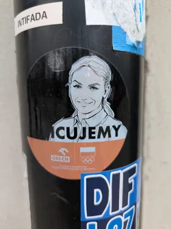 Street sticker The sticker features an illustration of tennis player Iga Świątek, in a black and white sketch style, above the text "Kibicujemy" with the Orlen logo and the Polish Olympic Committee logo. The sticker likely promotes Polish athletes.