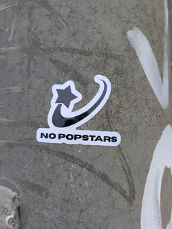 Street sticker The sticker shows a black star connected to a swoosh-like design. Below the design, the text "NO POPSTARS" is printed in black on a white background.