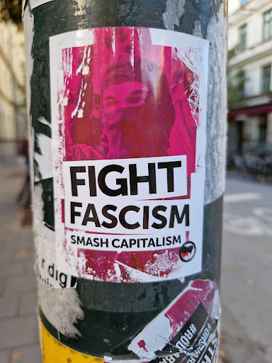 Street sticker A sticker featuring a person wearing a balaclava with the text 'FIGHT FASCISM' and 'SMASH CAPITALISM'.