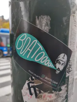 A black sticker with teal lettering that says BOATOooo. in a speech bubble. There's an illustration of a man with a beard and a bandana.  A website and Instagram handle are visible at the bottom.