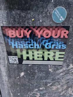A sticker with the text "BUY YOUR Hash/Gras HERE" in a stylized font. It includes a QR code.