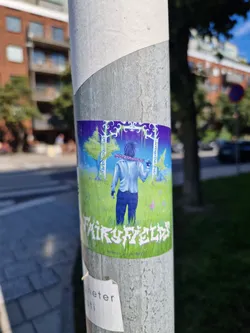 Street sticker This sticker features an illustration of a person with long hair walking away from the viewer towards what appears to be a mystical scene with trees and an arch. The background is a gradient of purple and blue, transitioning to green at the bottom, with a grassy field.  The sticker has the text "FairyFields" prominently displayed at the bottom.