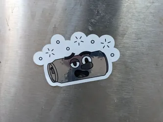 Street sticker A sticker featuring a cartoon illustration of a tired can of soda. The can has a face with sleepy eyes and a surprised expression. There are small stars around the can, suggesting energy or excitement. The can is drawn with a slightly distressed or used look. The sticker is likely made with a vinyl or similar material.