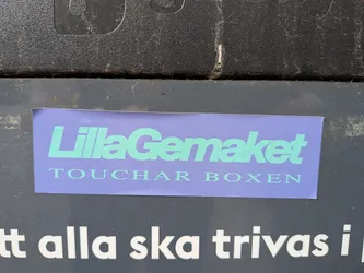 Street sticker A rectangular lavender sticker featuring mint green text. The top line reads 'LillaGemaket' in a bold sans-serif font, and the bottom line reads 'TOUCHAR BOXEN' in a smaller, spaced serif font.