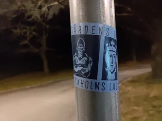 Street sticker A sticker featuring a gorilla and a king's face, with text reading "Gården's Stockholms Lag". The design is primarily blue and white.  It appears to be a logo or emblem.