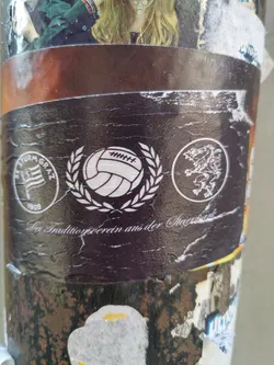 A dark-colored sticker featuring the logo of SK Sturm Graz, a football club from Graz, Austria.  It includes a football inside a laurel wreath, and other design elements. The text 'Der Traditionsverein aus der Murstadt' is visible, which translates to 'The traditional club from the Mur River city'.