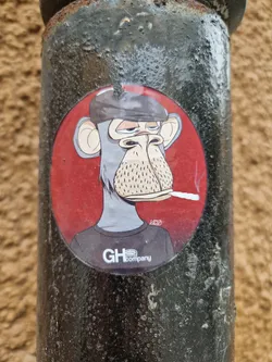 Street sticker A round sticker featuring a cartoon illustration of a monkey wearing a beret and smoking a cigarette. The monkey has a relaxed expression and is set against a red background. The sticker has the logo 'GHcompany' at the bottom.