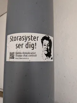 Street sticker White rectangular sticker on a grey pole. Features a high-contrast black portrait of a woman on the right and Swedish text on the left warning 'Big Sister is watching you!', protesting 'chat control' with a QR code and URL.