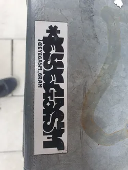 Black and white sticker with the word "Eyegasm" stylized in a unique font.  The Instagram handle is also visible on the sticker.