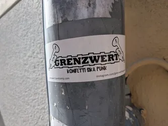 Street sticker A white rectangular sticker featuring the bold black text 'GRENZWERT' inside a gear-like border, flanked by two trumpet illustrations. Below, it reads 'KONFETTI SKA PUNK' with bandcamp and Instagram links at the bottom.