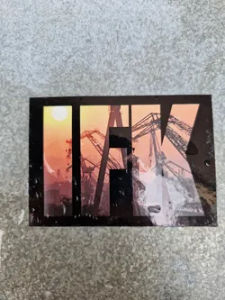 Street sticker A sticker featuring the letters IFK overlaid on a sunset image of harbor cranes. The sticker has a slightly worn look, suggesting it may have been placed outdoors for some time. 