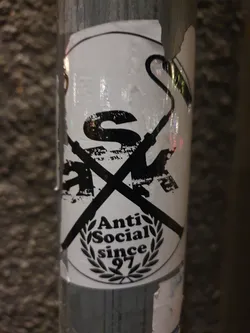 Black and white sticker with a crossed-out logo and the text 'Anti Social since 97' within a laurel wreath. 