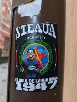 Street sticker A sticker depicting a football player from Steaua Bucuresti, a Romanian football club, with the club's logo and the year 1947. The text "Steaua Bucuresti" and "Clubul de langa inima 1947" is visible on the sticker.