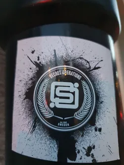 Black and white sticker with a logo featuring a stylized "SI" inside a wreath, surrounded by a paint splatter effect. The text "Secret Operations" is present above the logo, along with "Est. 2002" and "SWEDEN" below.