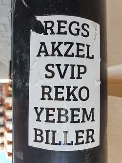 A sticker with a vertically stacked list of words, possibly names or abbreviations.  The words are printed in a bold, sans-serif typeface on a white background.