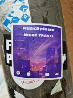 Street sticker A purple sticker featuring an illustration of a city street at night, with rain drops visible on the surface. The artist's name 'MusicBySober' and album title 'Night Travel' are prominently displayed.  Social media links for Spotify, Apple Music, and YouTube Music are shown at the bottom, along with the location 'Hannover'.