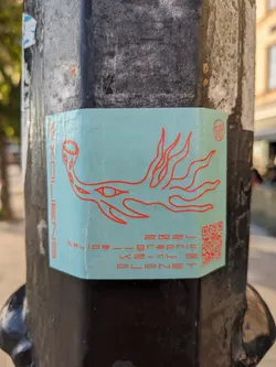 Street sticker A light teal sticker with a red graphic of a creature with eyes and flames. The text on the sticker indicates '2024 Slide - Graphic K2-14b PLANET'. A QR code is present on the sticker.