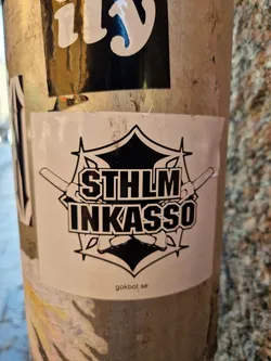 Street sticker Black and white sticker with the text STHLM INKASSO in a stylized logo.  The logo features two crossed swords or knives and a geometric shape resembling a star or crest.  The website gokbot.se is printed at the bottom of the sticker.