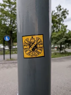 Street sticker A square yellow sticker featuring the black crest of the Swedish sports club AIK. The crest includes a central shield with 'A.I.K.' and '1891', topped by a crown and star, and enclosed in a wreath.