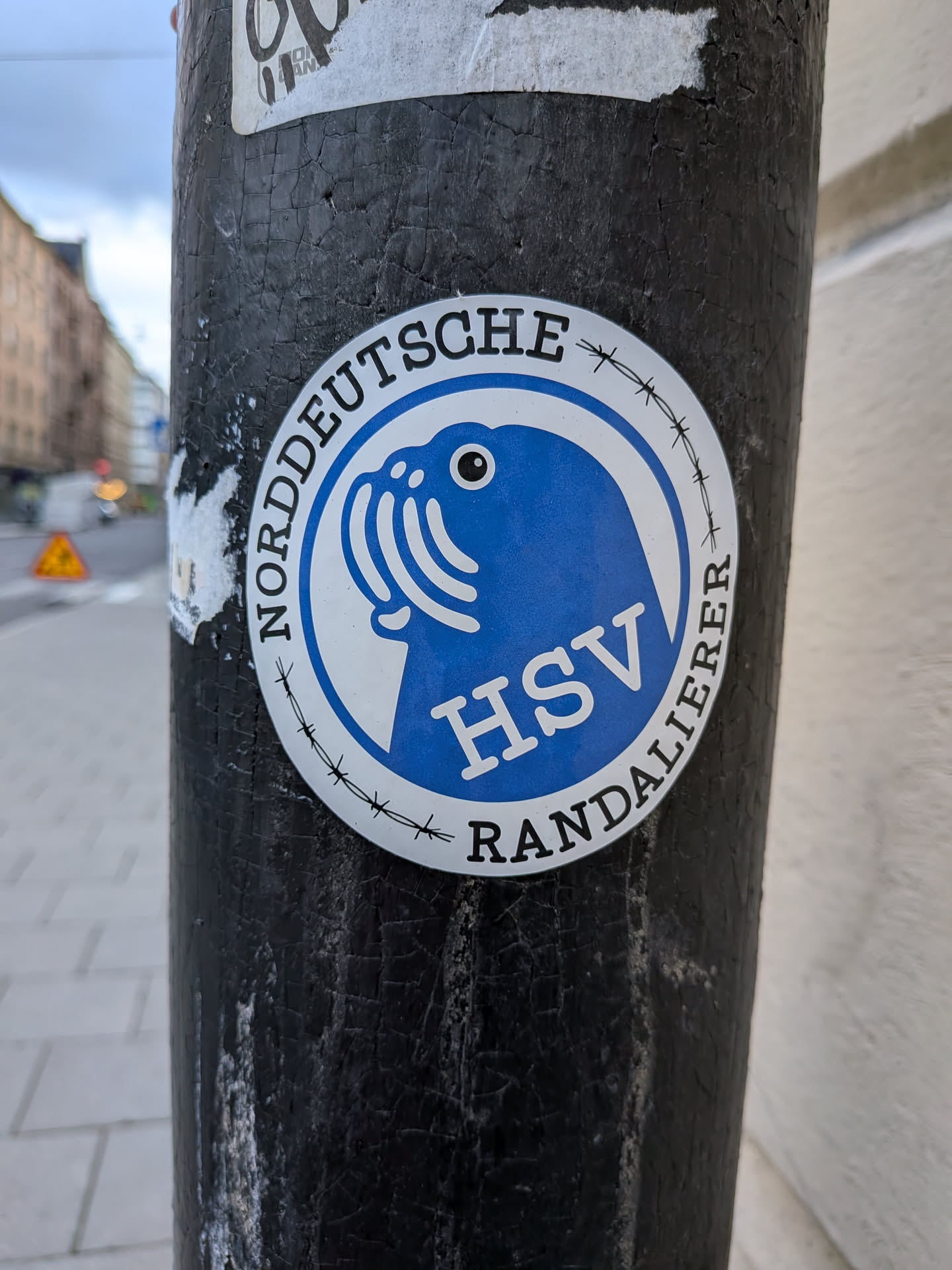 A round sticker with a blue inner circle showing a stylized walrus head and the letters 'HSV'. The outer white border contains the text 'NORDDEUTSCHE RANDALIERER' separated by barbed wire graphics.