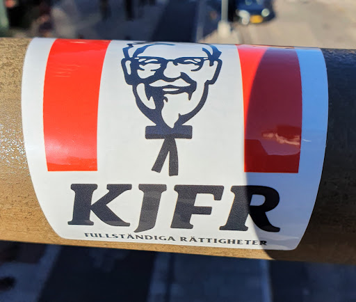 Street sticker A sticker featuring Colonel Sanders, the KFC mascot, with the acronym KJFR underneath.  The text "Fullständiga Rättigheter" is written in smaller text below the acronym.