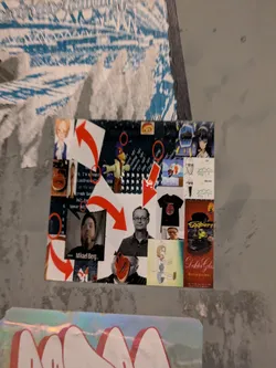 Street sticker The sticker is a rectangular, dark-background collage, likely printed, affixed to a light grey, textured wall. It features a chaotic yet engaging arrangement of various images and text. Prominent elements include: two distinct anime-style female characters (one with light hair and a blue top, another with dark hair), a cartoon bird character resembling Falco from Star Fox, and two different black and white portraits of men (one with a beard, identified as "Mikael Berg...", and another with glasses). There are also abstract red mask-like faces, a black t-shirt with a red design, and a red vertical panel featuring a green character with a top hat (labeled "Eggbert" and "Doktor Glo"). Large, bold red curved arrows are strategically placed, directing attention across the collage. Scattered text snippets, some appearing like code or internet slang ("word 101", "coding 101", "I'm a teapot"), add to the digital/internet culture theme. The overall color scheme is dark (background) with pops of red, blue, and various skin tones from the character images.