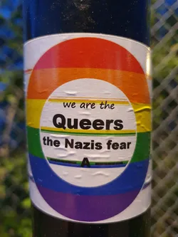 A sticker with a rainbow design and the text "We are the Queers the Nazis fear".