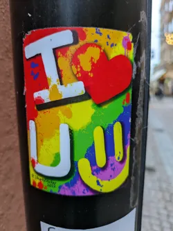 Street sticker A vibrant sticker featuring the letters 'I' and 'U' embraced by a red heart, set against a rainbow backdrop of colorful paint splatters.  A stylized smiley face completes the design. The text \u00a9ILikeSticker 2022 is visible in the bottom left corner.