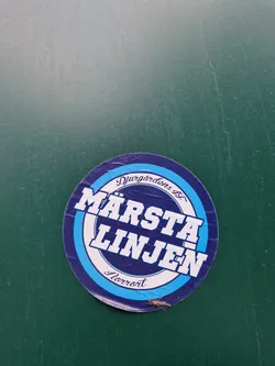 Street sticker A round sticker featuring the text "Märsta Linjen" in a bold, stylized font.  The words "Djurgårdens" and "Herrort" appear in smaller text above and below the main text respectively.  The sticker has a blue, white, and dark blue color scheme. 