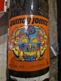 Street sticker Psychedelic skull sticker with vibrant colors and intricate details. The sticker features a melting pot design with multiple faces surrounding a central skull, all adorned with floral and mushroom motifs.  Text on the sticker includes "Quincy Jointz", "Melting Pot", and a SoundCloud link.