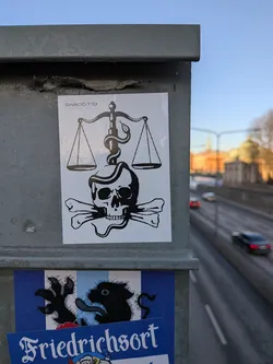 Street sticker The sticker is a rectangular, black and white design. It prominently features a human skull with two crossbones positioned beneath it, in the style of a Jolly Roger. Above the skull, a classic set of scales of justice is depicted, with two empty pans. A snake is intricately wrapped around the central pillar of the scales, its head near the top pan, and its body extending down to coil around the skull. The entire illustration is rendered in bold black lines and solid black fills against a clean white background.