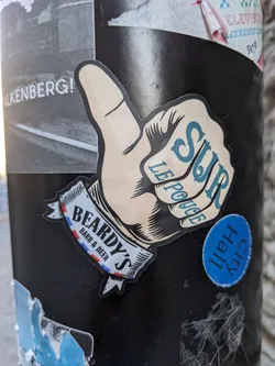 A sticker featuring a hand giving a thumbs up. The text on the sticker says "SUR LE PONT" and "BEARDY'S BARB & BEER".
